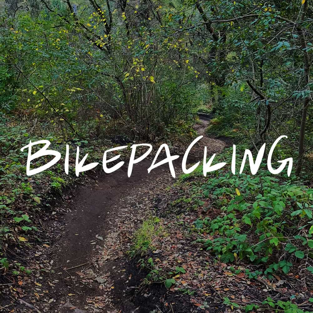 The word BIKEPACKING sits over an image
